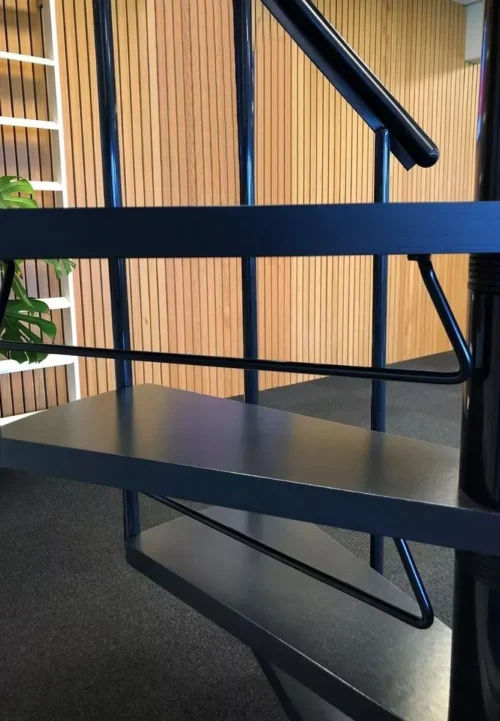 crna sigurnosna prečka (riser bar) ispod stepenica spiralnog stubišta – dodatna zaštita i moderan izgled