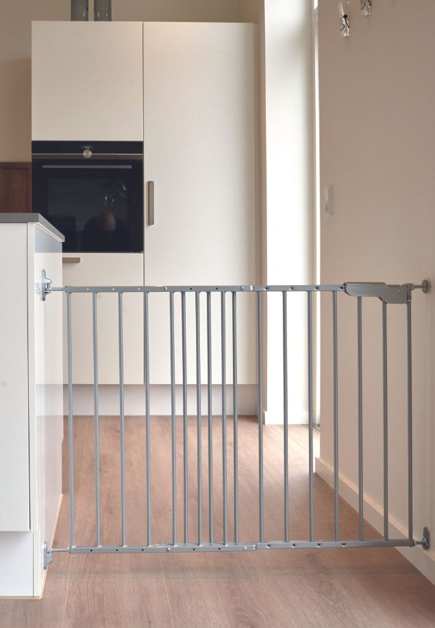 srebrna sigurnosna ograda LARS postavljena između kuhinjskog elementa i zida na drvenom podu