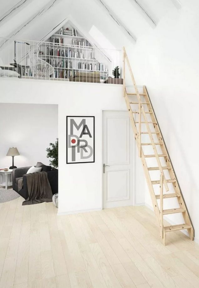 drvene potkrovne ljestve koje vode do bijele galerije s policama za knjige