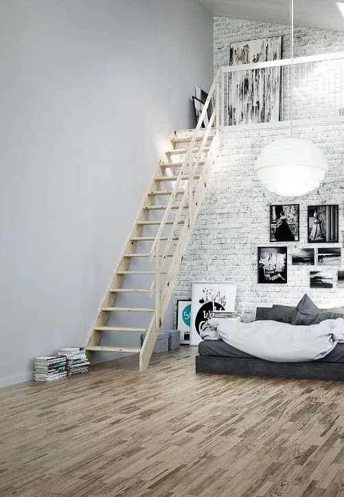 Funkcionalnost i toplina drveta – stubište NORMANDIE u suvremenom uređenju drvene stepenice NORMANDIE vode na galeriju u modernom potkrovlju s bijelim zidom od opeke i niskim sivim krevetom