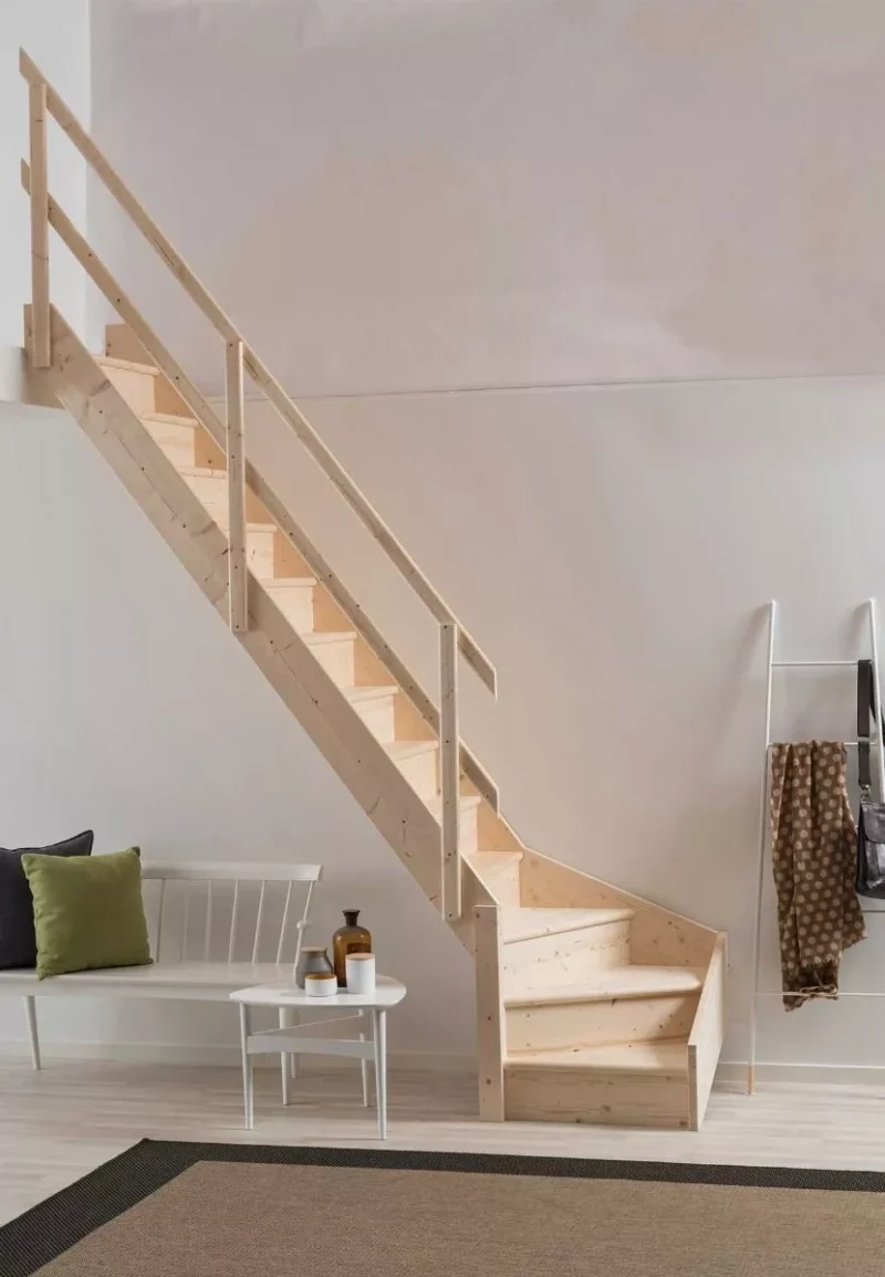 raktičan kutni dizajn – NORMANDIE stubište štedi prostor i donosi toplinu drva u svaki interijer drveno stubište modela NORMANDIE s kutnim donjim stepenicama uz svijetli zid i dekorativne stoliće