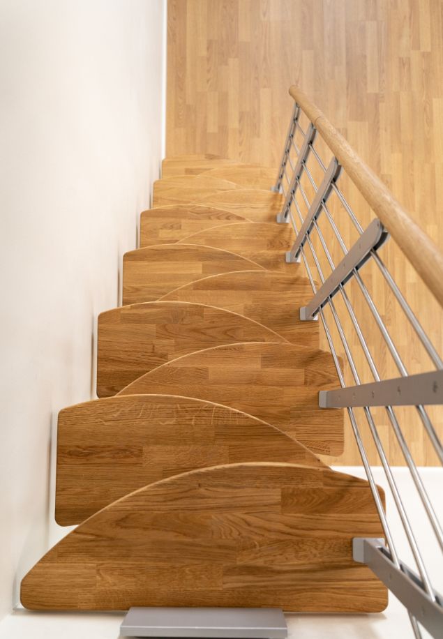 pogled odozgo na modularne stepenice s rotacijskim gazištima, drvenim rukohvatom i metalnom ogradom uz zid