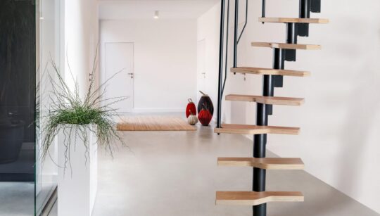 moderné kompaktné schody MINI ATHENA s čiernou kovovou konštrukciou a svetlými drevenými stupňami v minimalistickom interiéri