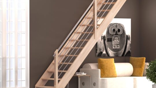 drvene stepenice s metalnim rukohvatom u svijetlom interijeru s tamno smeđim zidom i bijelim kaučem s jastucima