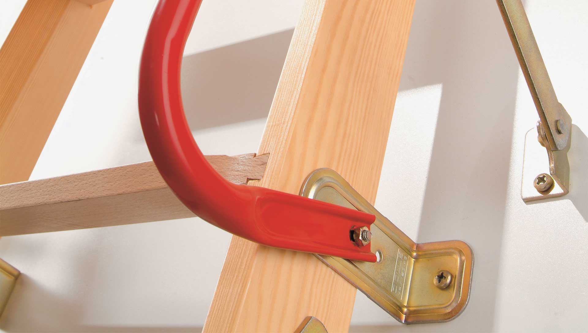 Dodatna oprema za potkrovne ljestve detalj crvene ručke montirane na drvene potkrovne ljestve s metalnim nosačem