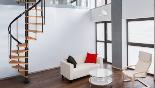 unutarnje spiralno stubište s drvenim gazištima i crnom konstrukcijom u modernoj dnevnoj sobi