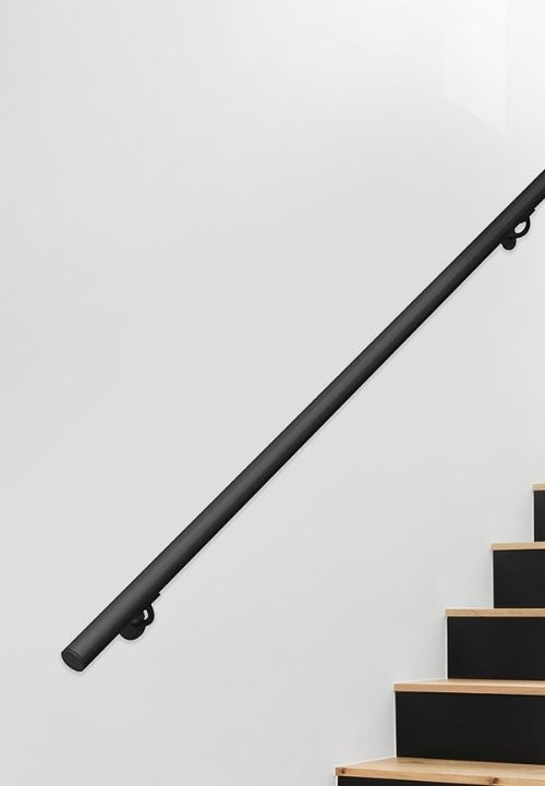 Na fotografiji se vidi crni, minimalistički zidni rukohvat postavljen uz moderno stubište s drvenim gazištima.