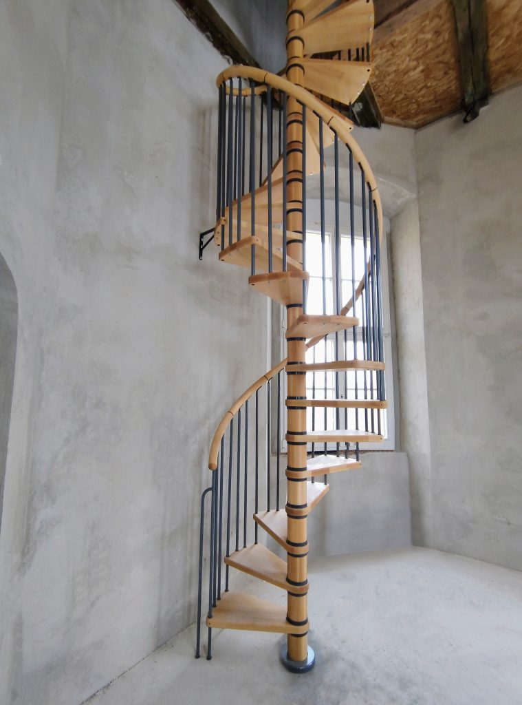 Drvene spiralne stepenice s metalnom ogradom u povijesnom interijeru palače