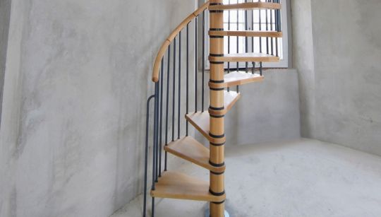 Drvene spiralne stepenice s metalnom ogradom u povijesnom interijeru palače