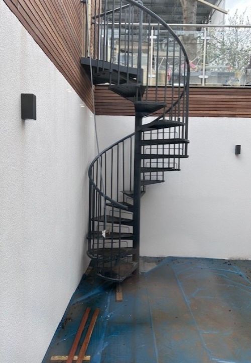 Antracitno spiralno stubište DOLLE TORONTO s podestom koje vodi na terasu uz modernu izvedbu zimskog vrta